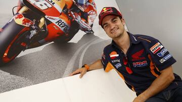 Dani Pedrosa posando delante de una foto pilotando su Honda.