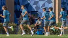Simeone observa a sus futbolistas, sobre su nevera y con sus muletas, mientras ejecutan el test de Course-Navette en el primer entrenamiento en Los Ángeles de San Rafael.