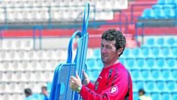 <b>MOTIVADO. </b>Juan Carlos Mandiá recoge un muñeco de plástico para las barreras, durante una sesión en el estadio Rico Pérez.