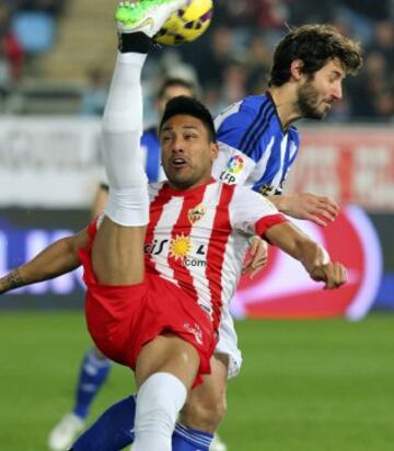 El defensa argentino del Almería Mauro Dos Santos despeja un balón junto a Esteban Granero.