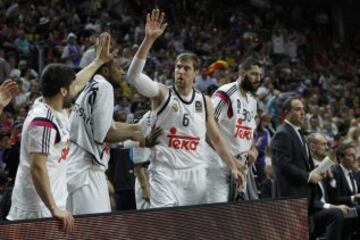 Campazzo y Slaughter felicitan a Nocioni en el banquillo madridista.