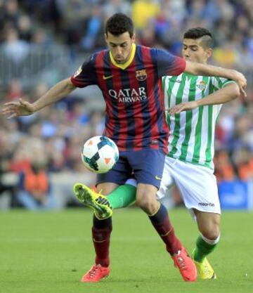 El centrocampista del Barcelona Sergio Busquets (primer término) y el defensa del Betis Juan Francisco Moreno luchan por el balón.