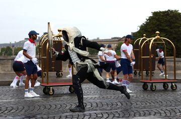 El portador de la antorcha pasa corriendo por el Pont Neuf durante la ceremonia de apertura de los Juegos Olímpicos de París 2024.