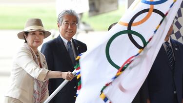 Tokyo Governor Yuriko Koike (L) waves the Olympic flag beside Japan Olympic Committee (JOC) President Tsunekazu Takeda (2nd L) upon its arrival at Haneda Airport in Tokyo on August 24, 2016. The Olympic flag arrived in Tokyo on August 24 as Japan's capit