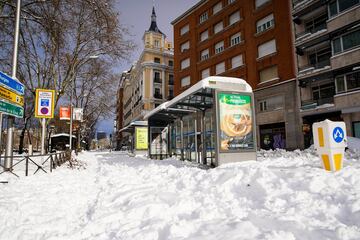 Parada de bus cubierta de nieva. 