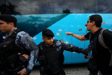 La policía intenta proteger el autobús en el que viajan los jugadores de la selección brasileña de fútbol durante una protesta de maestros de Río de Janeiro.