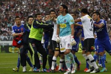 El 21-10-2012, Colo Colo derrotó 1-0 a la U en el Monumental, con gol de Carlos Muñoz. Tras el partido, el arquero Francisco Prieto se burló de la barra azul Los de Abajo. Ese gesto enojó a Johnny Herrera, quien corrió todo el campo para increpar al golero albo. Ambos fueron expulsados después del partido, junto a Gonzalo Fierro.