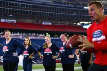 Rob Gronkowski enseña los fundamentos del fútbol americano a un grupo de mujeres.