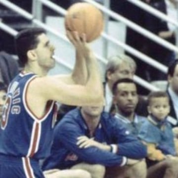 Drazen Petrovic lanza durante el concurso de triples de 1992 en Orlando bajo la mirada de Stephen Curry, sentado en las rodillas de su padre Dell.