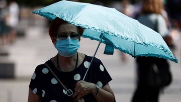 GRAF3734. MADRID, 23/07/2020.- Una mujer pasea por el centro de la capital protegida con una sombrilla, este jueves. Un mes después del inicio del verano, y a pesar del ambiente sofocante, sobre todo en puntos del oeste y suroeste peninsular con máximas de hasta 42 grados, aún no se ha activado ningún aviso por ola de calor, lo que no implica, que la temporada estival finalice batiendo récords de temperaturas. EFE/ Mariscal