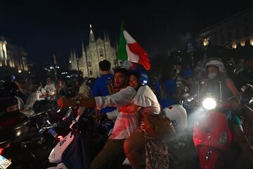 Los aficionados italianos celebran la victoria de su selección en la plaza del Duomo en Milán.