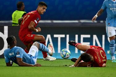 Erik Lamela inteneta controlar el balón con Manuel Akanji e Ivan Rakitic tirados sobre el césped.