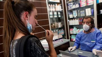 GRAFCAT6396 Hospitalet de Llobregat (BARCELONA) 19/7/2021.- El farmacèutico comunitario y vocal de la Oficina de Farmàcia del Colegio de Farmacèuticos de Barcelona (COFB) Guillermo Bagaría (d), explica y supervisa a jóvenes y monitores de colonias de cómo realizar los autotests de antígenos en la farmácia Bagaría Casanova de l´Hospitalet de Llobregat . EFE/Quique Garcia