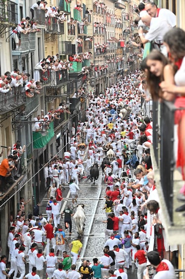 Participantes corren delante de los toros durante el primer encierro de los Sanfermines en Pamplona.