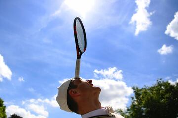 Un malabarista hace equilibrio con una raqueta sujetada por la cabeza en los anexos de Roland Garros.