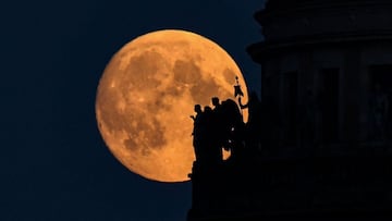 The full moon is pictured behind sculptures on the Saint Icaas&#039;s cathedral in Saint Petersburg late on June 23, 2021. (Photo by Kirill KUDRYAVTSEV / AFP)