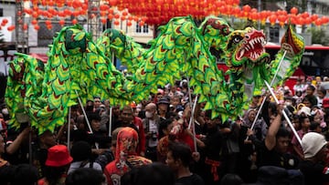 SOLO CITY, INDONESIA - JANUARY 15: Chinese dragon dancers perform during Grebeg Sudiro festival as part of the Lunar New Year celebrations on January 15, 2023 in Solo City, Indonesia. Grebeg Sudiro festival is held as a prelude to the Lunar New Year, which falls on January 22th this year, welcoming the Year of the Rabbit. People bring offerings known as gunungan, including Chinese sweet cakes piled up into the shape of mountains, which are paraded in the streets followed by Chinese and Javanese performers. (Photo by Robertus Pudyanto/Getty Images)