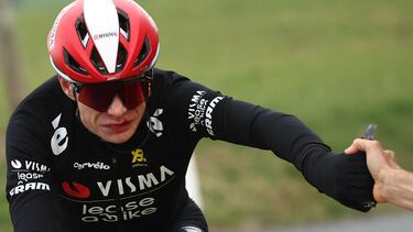 Team Visma-Lease a Bike's Danish rider Jonas Vingegaard grabs an enegry gel from his team's car as he cycles after falling during the 5th stage of the Paris-Nice cycling race, 203,3 km between Saint-Just-en-Chevalet and La C�te-Saint-Andr�, on March 13, 2025. Vingegaard tumbled on the Treves climb midway through the stage as he was leading heading towards the finish line in the Isere region in southeastern France. After a visit to the medical car, he quickly returned to the peloton -- but with blood pouring from his cut lip -- to finish 16th, nearly half a minute off the pace. (Photo by Anne-Christine POUJOULAT / AFP)