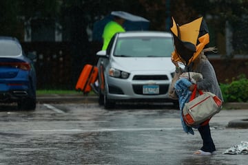 Una mujer sostiene un paraguas mientras llega a un refugio mientras se acerca el huracán Milton, en Lakeland, Florida.