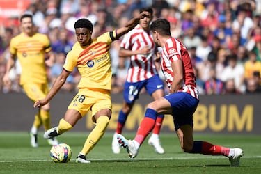 El defensa del Barcelona, Alejandro Balde, compite con el defensa uruguayo del Atlético de Madrid, José Giménez.