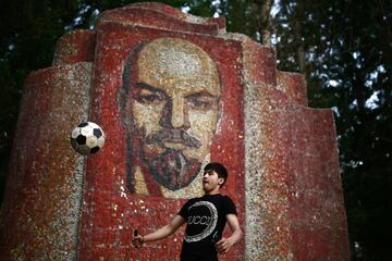 Un niño juega con un balón delante de un mosaico del líder comunista Vladimir Lenin, en Kazan.
