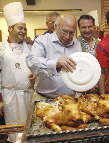 Entrañable imagen de Lázaro Albarracín partiendo cochinillos a la manera tradicional durante la comida del equipo rojiblanco en la concentración en Los Ángeles de San Rafael (Segovia) de 2011. 
 
