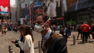 A man wears a protective face mask walking through Times Square during warnings by officials of heavy pollution after thick haze and smoke caused by wildfires in Canada covered the area, in New York City, U.S., June 8, 2023. REUTERS/Shannon Stapleton