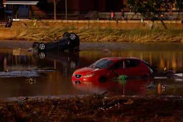 Los coches yacen parcialmente sumergidos tras las inundaciones en Utiel, España.