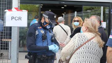 Un policía municipal pide la documentación a una mujer antes de entrar al Centro Cultural Lope de Vega, en la Zona Básica de Salud (ZBS) de Puente de Vallecas