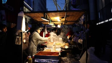 SEOUL, SOUTH KOREA - DECEMBER 25: A street vender is seen at the Myeongdong shopping district during Christmas Day on December 25, 2021 in Seoul, South Korea. Government expressed concerns about some religious establishments preparing for year-end events and gatherings ahead of Christmas and asked such facilities to strictly follow the state-mandated disease control measures. Under the new Covid measures, which will be in effect from Saturday until Jan. 2, the use of restaurants and cafes will be restricted to up to four vaccinated people per visit. Bars, nightclubs and other entertainment venues will also be subject to the 9 p.m. (Photo by Chung Sung-Jun/Getty Images)