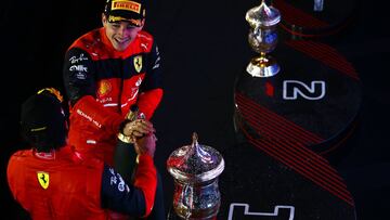 BAHRAIN, BAHRAIN - MARCH 20: Race winner Charles Leclerc of Monaco and Ferrari and Second placed Carlos Sainz of Spain and Ferrari celebrate on the podium during the F1 Grand Prix of Bahrain at Bahrain International Circuit on March 20, 2022 in Bahrain, B