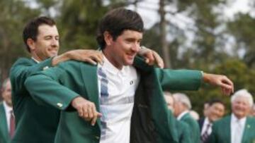 Adam Scott poniéndole la chaqueta verde a Bubba Watson.