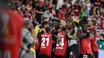 Bayer Leverkusen's players celebrate with Finnish goalkeeper #01 Lukas Hradecky after winning the penalty shoot-out of the German Supercup football match between Bayer 04 Leverkusen and VfB Stuttgart in Leverkusen, western Germany on August 17, 2024. (Photo by Sascha Schuermann / AFP) / DFL REGULATIONS PROHIBIT ANY USE OF PHOTOGRAPHS AS IMAGE SEQUENCES AND/OR QUASI-VIDEO