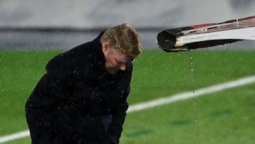 Barcelona&#039;s Dutch coach Ronald Koeman protects himself from the rain during the &quot;El Clasico&quot; Spanish League football match between Real Madrid CF and FC Barcelona at the Alfredo di Stefano stadium in Valdebebas, on the outskirts of Madrid o