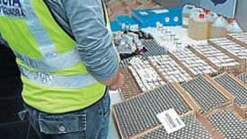 <b>FÁRMACOS. </b>Un policía ante el material incautado ayer.