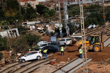 Una vista muestra vehículos en una vía de tren dañada, luego de fuertes lluvias que provocaron inundaciones,  en Sedaví, Valencia.