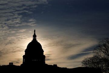 The sun rises behind the US Capitol in Washington DC on Tuesday, ahead of President Biden's maiden State of the Union address.