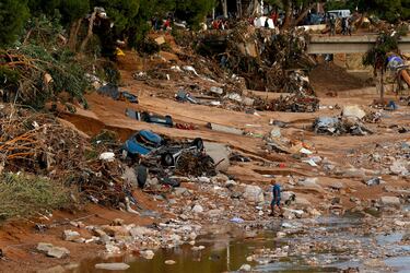 Un hombre se abre paso entre el barro y los escombros tras las lluvias torrenciales que provocaron inundaciones, en Paiporta, Valencia.