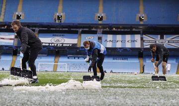 Operarios del Manchester City retiran el hielo del campo tras una granizada.