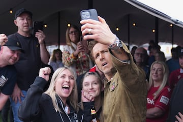 El copropietario del Wrexham, Ryan Reynolds (derecha), se toma una selfie con los aficionados en el estadio Racecourse antes del partido.