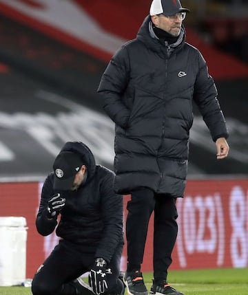 Hasenhutt, arrodillado, junto a Klopp cuando acabó el encuentro.