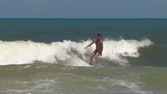 Un surfista surfea en la playa de New Smyrna despu&eacute;s del ataque. 