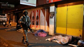 A member of the South African military walks past homeless people while patrolling the streets as a nighttime curfew is reimposed amid a nationwide coronavirus disease (COVID-19) lockdown, in Johannesburg, South Africa July 13, 2020. REUTERS/Siphiwe Sibek