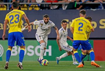 Dani Ceballos observa la progresión de su compañero, Karim Benzema, entre varios jugadores del conjunto gaditano.