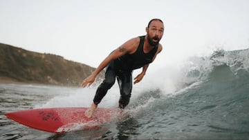 Kepa Acero surfeando una ola con su tabla de surf roja y su neopreno sin mangas Oxbow. 