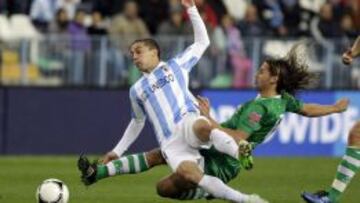 El delantero uruguayo del M&aacute;laga C.F., Seba Fernandez, cae ante la entrada del jugador del Cacere&ntilde;o Checa, durante el encuentro correspondiente a la vuelta de los dieciseisavos de la Copa del Rey, que disputan esta noche en el estadio de la Rosaleda en M&aacute;laga.