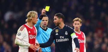 Referee Damir Skomina shows Sergio Ramos of Real Madrid a yellow card during the UEFA Champions League Round of 16