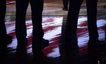 La bandera de Estados Unidos se refleja en el suelo mientras los jugadores guardan un minuto de silencio antes del comienzo del partido de la NBA que enfrentó a San Antonio Spurs - Golden State Warriors.