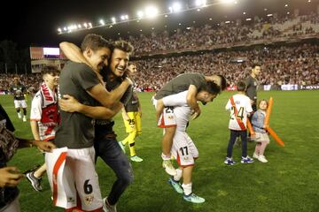 Afición y jugadores celebran sobre el terreno de juego la vuelta del Rayo Vallecano a Primera División.
    