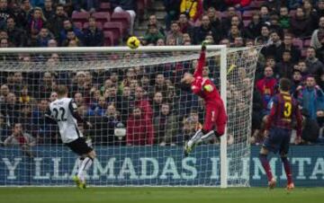 El portero brasileño del Valencia Diego Alves (c) no puede detener el balón lanzado por el delantero chileno del Barcelona Alexis Sánchez, en la jugada que ha supuesto el primer gol para el conjunto azulgrana durante el partido de la vigésimo segunda jornada de liga de Primera División, disputado esta tarde en el Camp Nou.